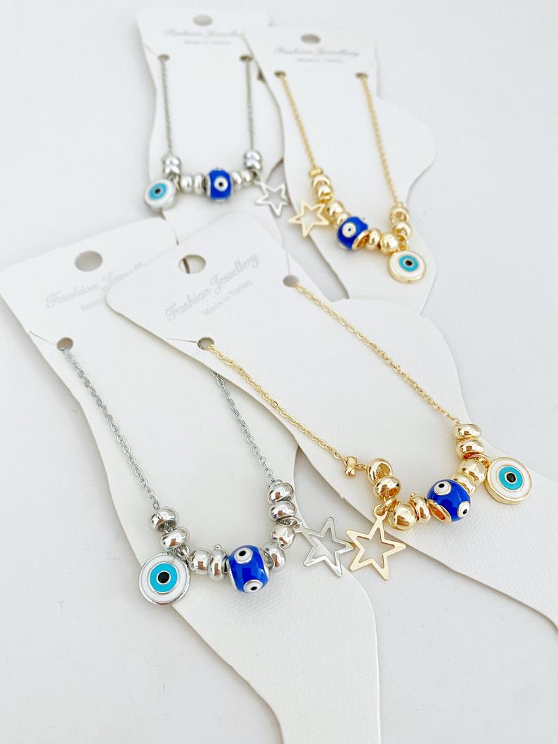 A stylish Blue Evil Eye Anklet featuring a blue evil eye charm and star charm, available in gold and silver finishes.