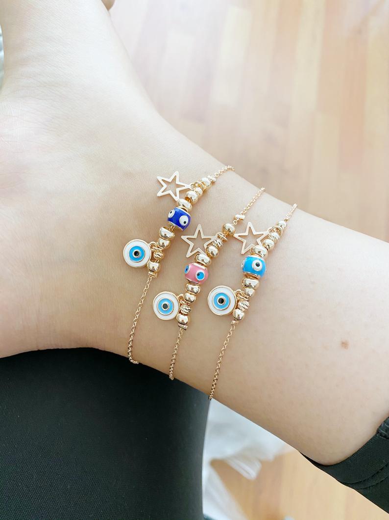 A stylish Blue Evil Eye Anklet featuring a blue evil eye charm and star charm, available in gold and silver finishes.