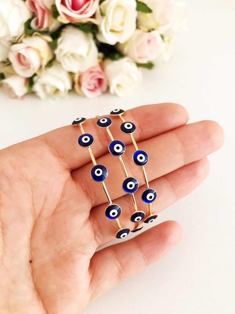 A beautiful Blue Evil Eye Bangle Bracelet featuring a movable oval charm and a round cuff design, crafted from durable stainless steel.