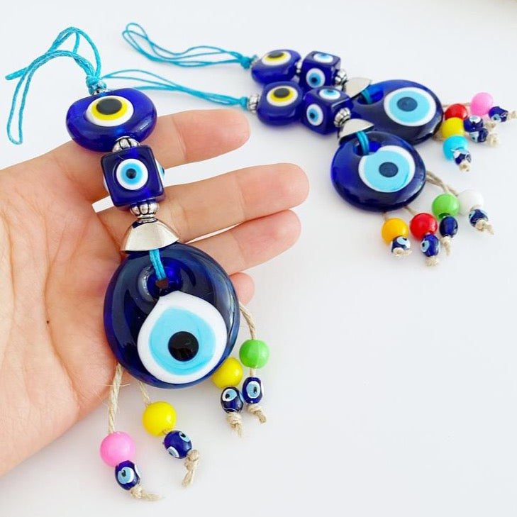 A beautiful Blue Evil Eye Bead car accessory, featuring a glass bead with a traditional Nazar design, hanging elegantly from a string.
