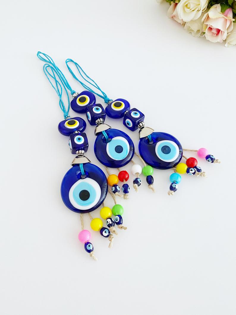 A beautiful Blue Evil Eye Bead car accessory, featuring a glass bead with a traditional Nazar design, hanging elegantly from a string.