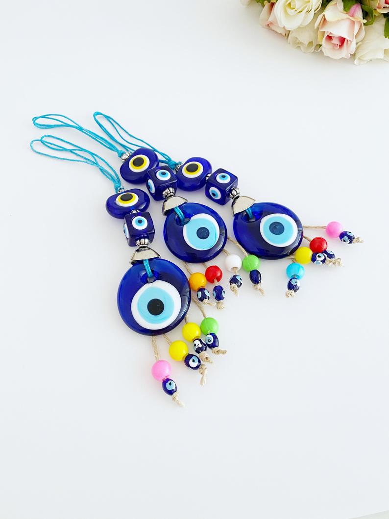 A beautiful Blue Evil Eye Bead car accessory, featuring a glass bead with a traditional Nazar design, hanging elegantly from a string.