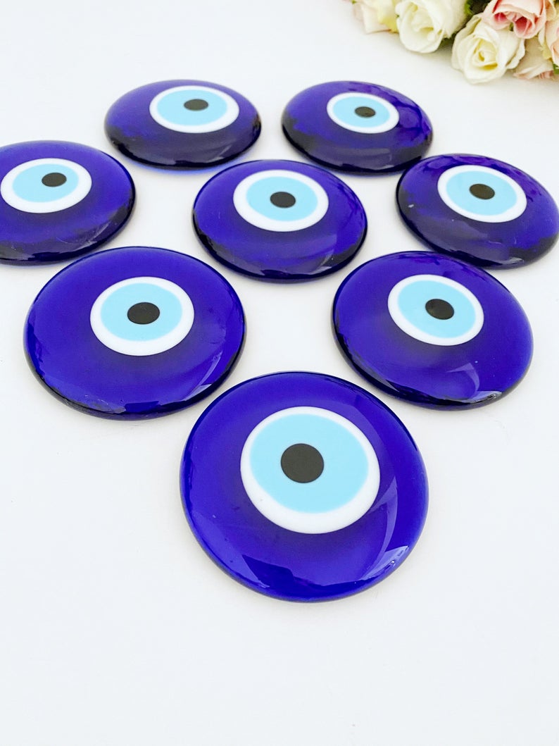 A 7cm handmade blue evil eye bead with no hole, showcasing intricate glasswork and vibrant blue color, symbolizing protection and good luck.