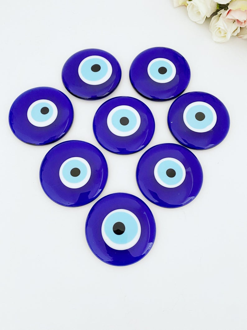 A 7cm handmade blue evil eye bead with no hole, showcasing intricate glasswork and vibrant blue color, symbolizing protection and good luck.