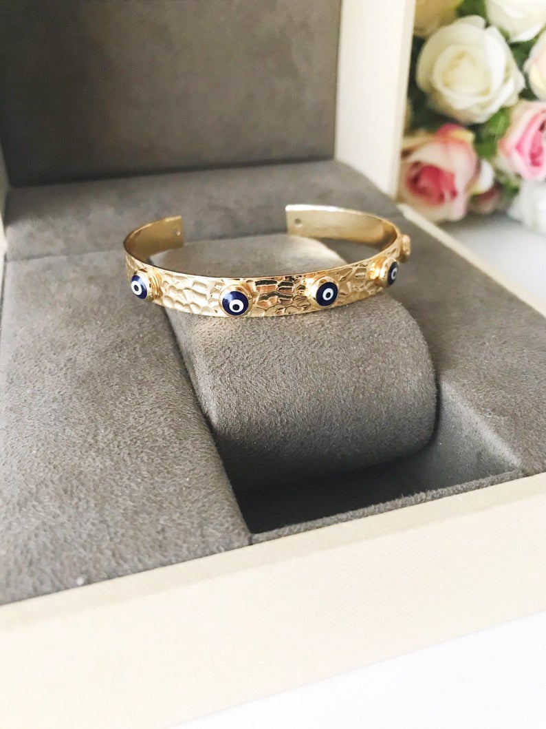 Blue Evil Eye Beaded Bracelet featuring tiny glass beads and a movable oval charm, available in rose gold, gold, and silver.