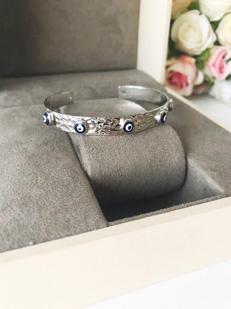 Blue Evil Eye Beaded Bracelet featuring tiny glass beads and a movable oval charm, available in rose gold, gold, and silver.