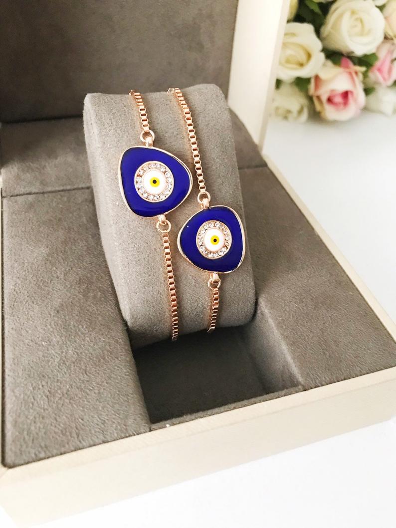 A beautiful blue evil eye bracelet featuring a 15mm charm, adjustable rose gold design, and made from tarnish-resistant stainless steel.