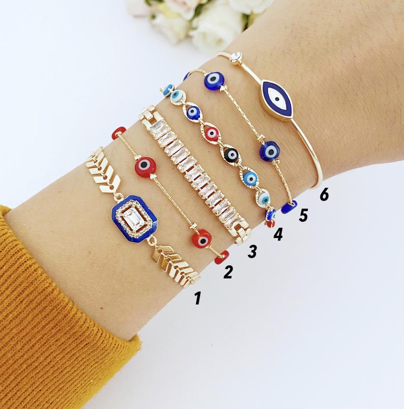 A beautiful Blue Evil Eye Bracelet featuring a gold chain and crystal CZ accents, showcasing its handmade craftsmanship and adjustable design.