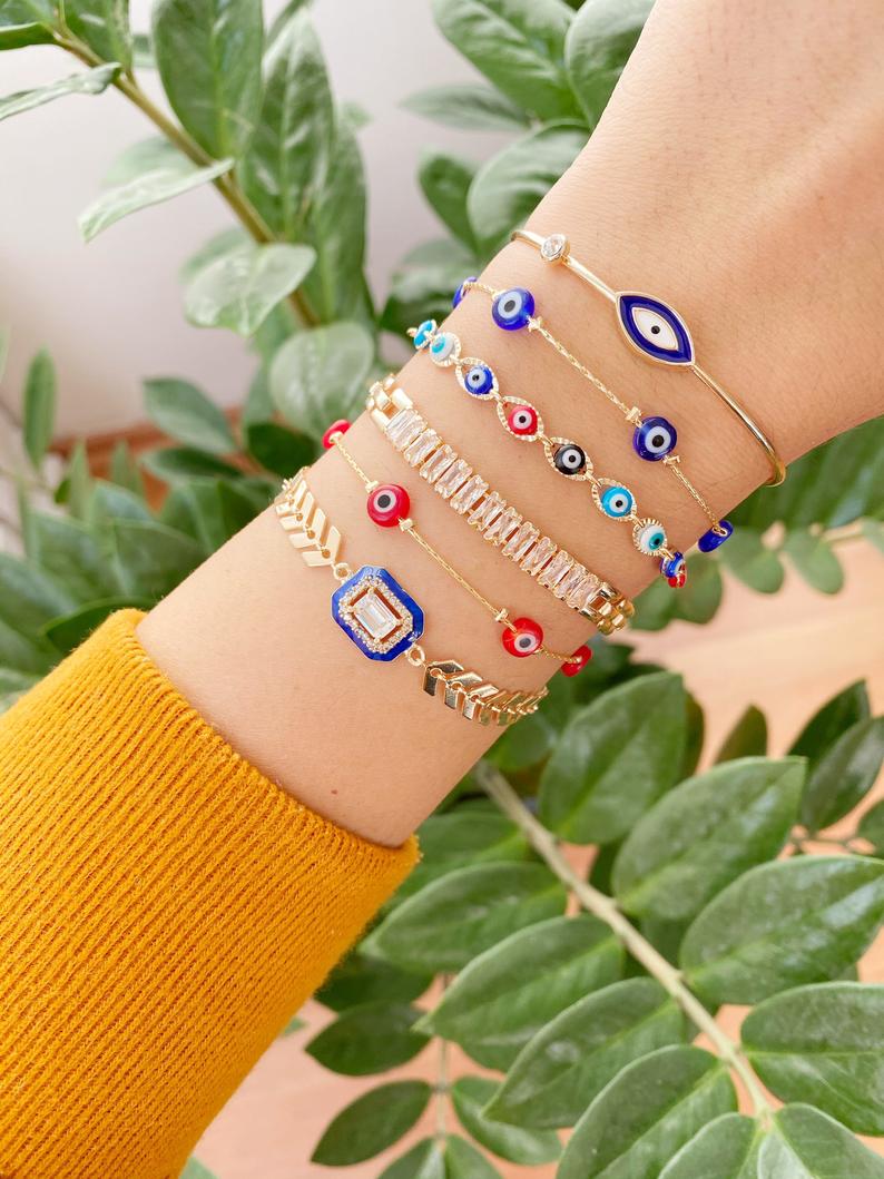 A beautiful Blue Evil Eye Bracelet featuring a gold chain and crystal CZ accents, showcasing its handmade craftsmanship and adjustable design.