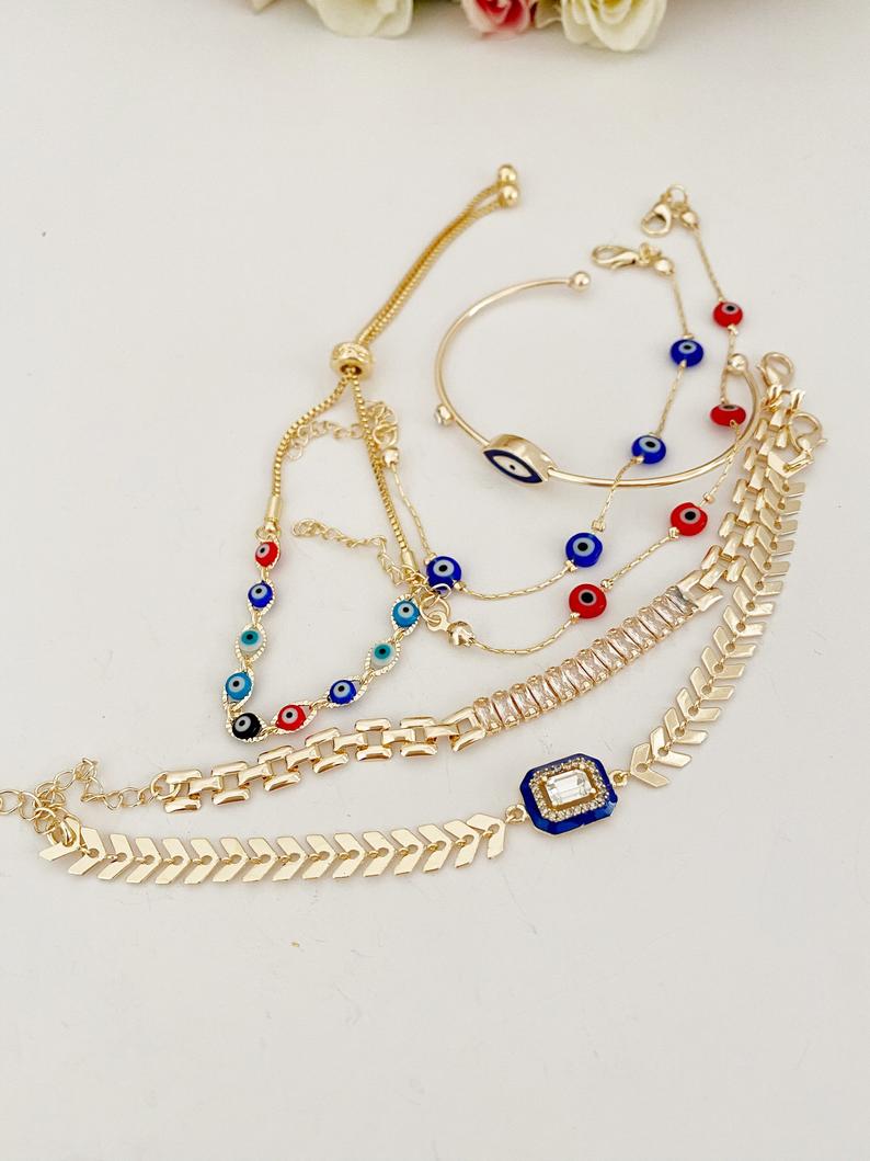 A beautiful Blue Evil Eye Bracelet featuring a gold chain and crystal CZ accents, showcasing its handmade craftsmanship and adjustable design.