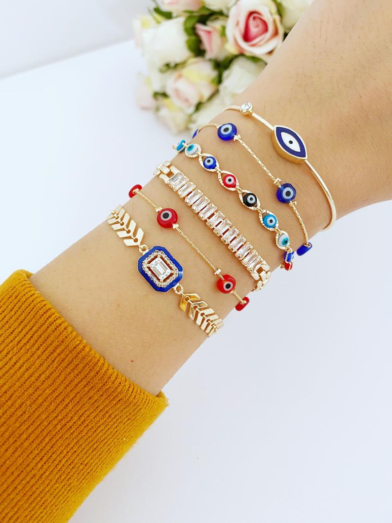 A beautiful Blue Evil Eye Bracelet featuring a gold chain and crystal CZ accents, showcasing its handmade craftsmanship and adjustable design.