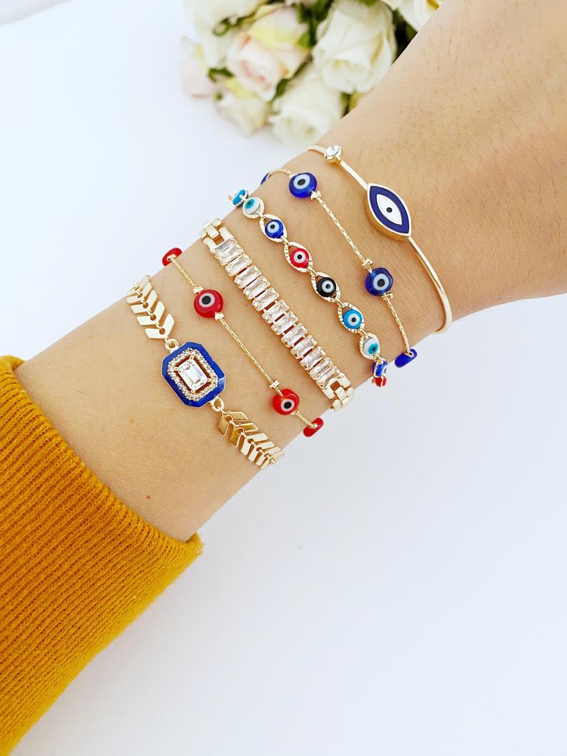 A beautiful Blue Evil Eye Bracelet featuring a gold chain and crystal CZ accents, showcasing its handmade craftsmanship and adjustable design.