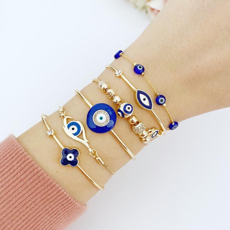 A beautiful Blue Evil Eye Bracelet featuring a gold cuff design, handmade from tarnish-resistant stainless steel.