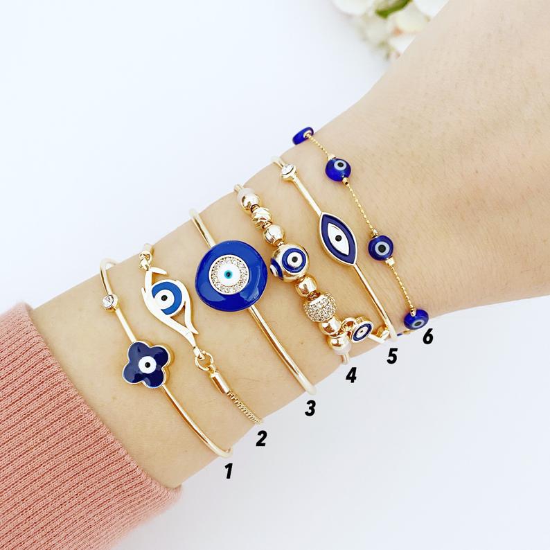 A beautiful Blue Evil Eye Bracelet featuring a gold cuff design, handmade from tarnish-resistant stainless steel.