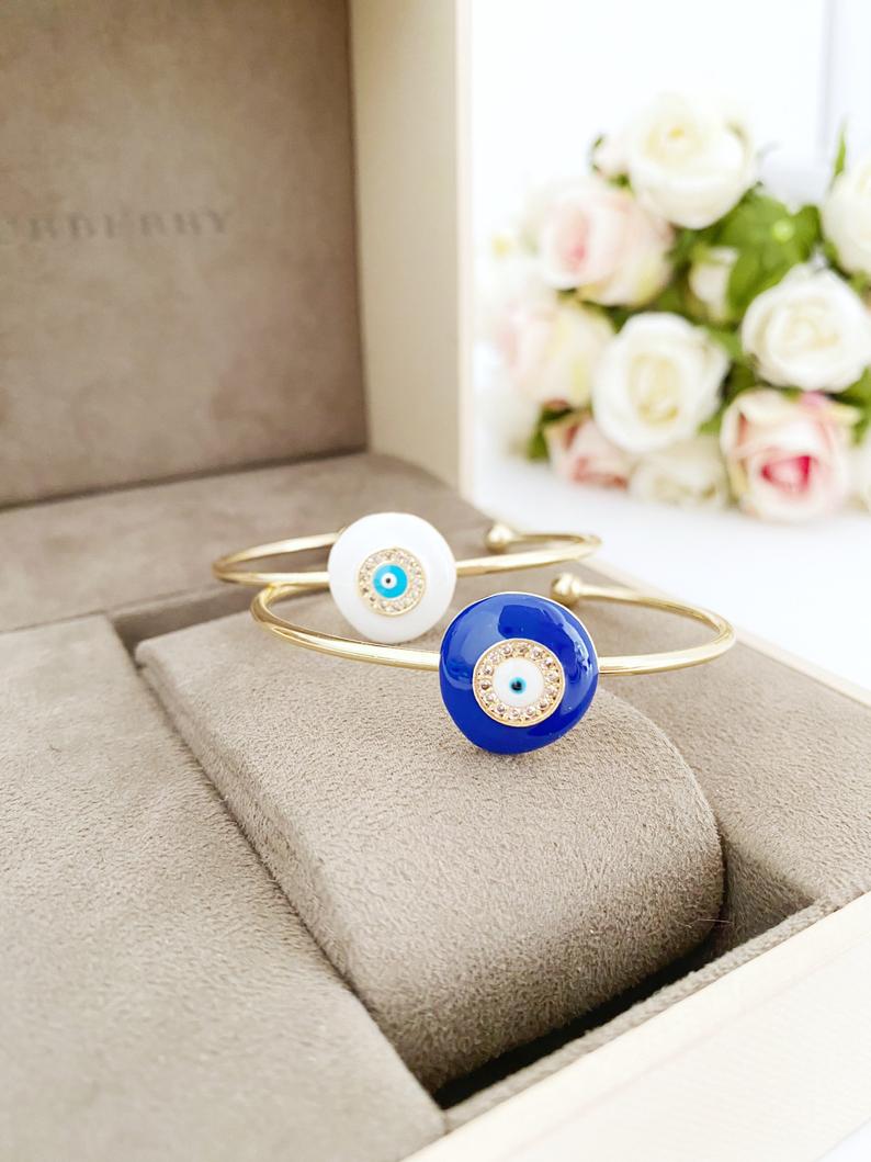 A beautiful Blue Evil Eye Bracelet featuring a gold cuff design, handmade from tarnish-resistant stainless steel.