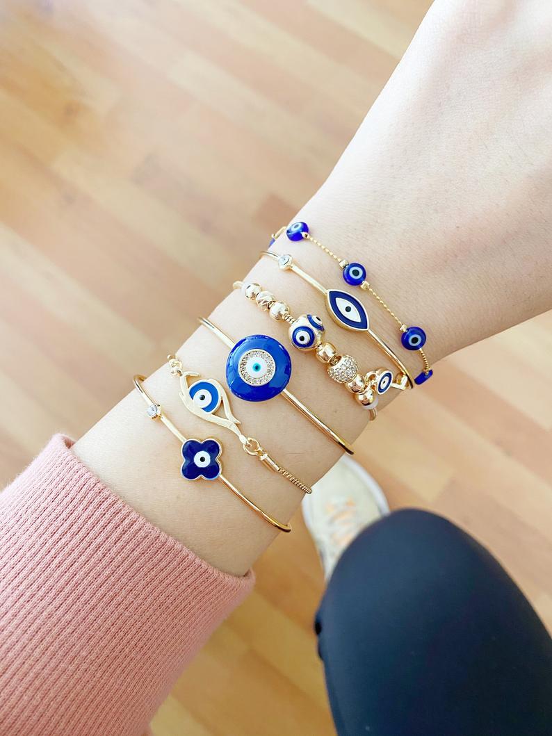 A beautiful Blue Evil Eye Bracelet featuring a gold cuff design, handmade from tarnish-resistant stainless steel.