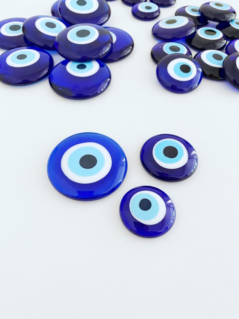 A collection of 10 blue glass evil eye beads without holes, showcasing various sizes from 3 to 5.5 cm, perfect for crafts and decorations.