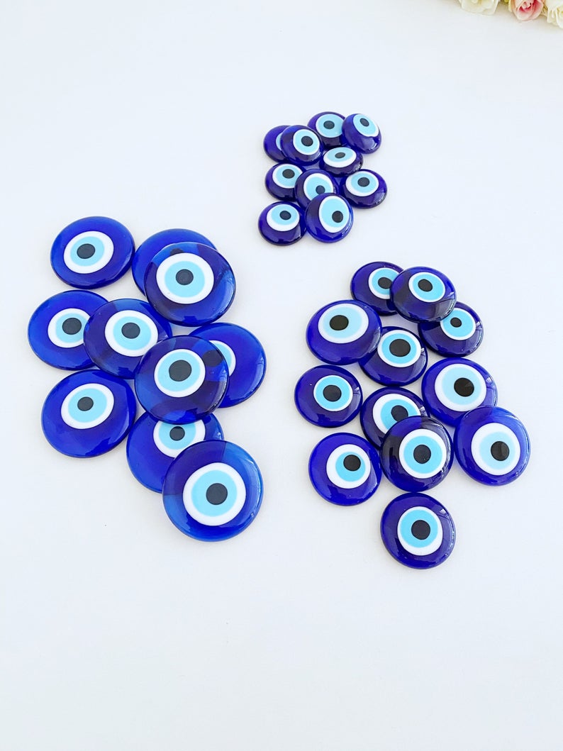 A collection of 10 blue glass evil eye beads without holes, showcasing various sizes from 3 to 5.5 cm, perfect for crafts and decorations.