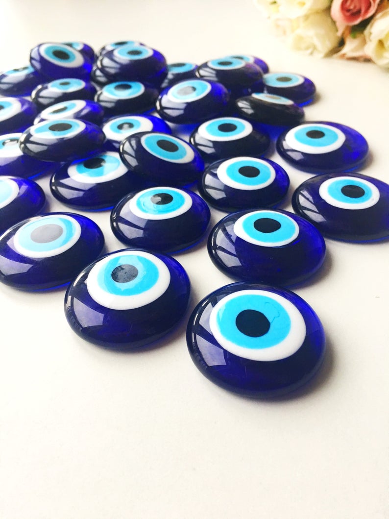 A collection of 10 blue glass evil eye beads without holes, showcasing various sizes from 3 to 5.5 cm, perfect for crafts and decorations.