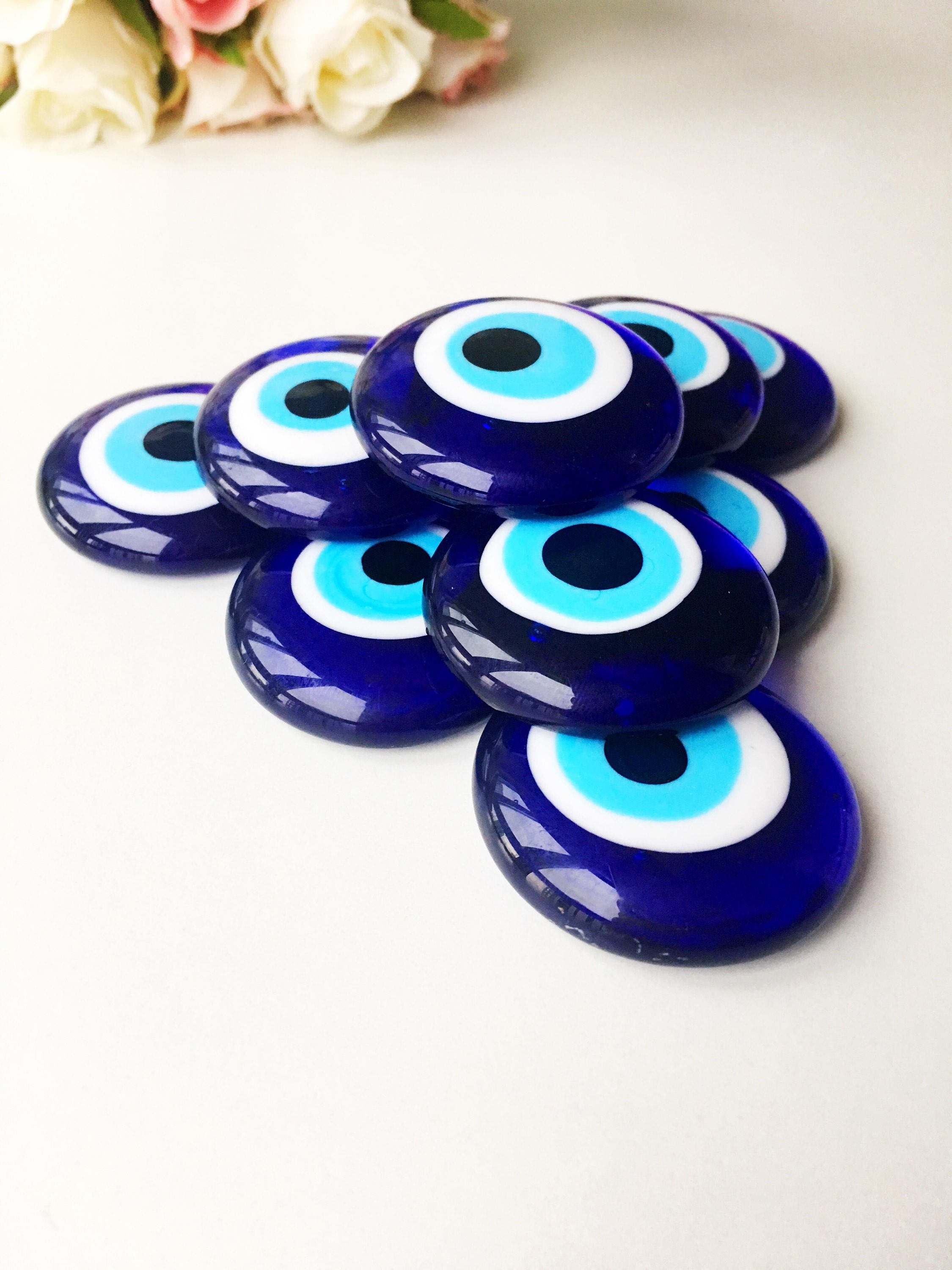 A collection of blue evil eye charm beads made of glass, showcasing their vibrant color and round shape, ideal for crafts and protection.