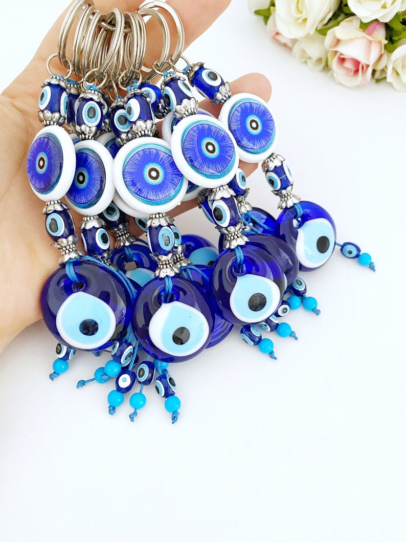 A beautiful blue evil eye keychain featuring a glass bead, symbolizing protection and good luck, attached to a silver keyring.
