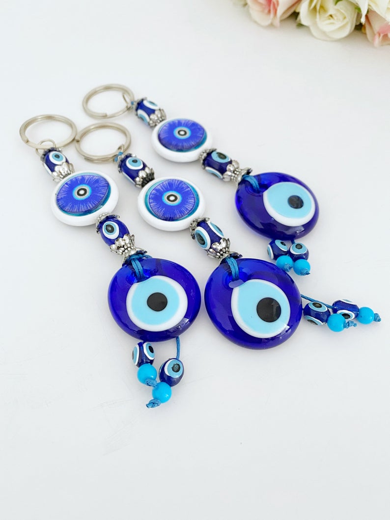 A beautiful blue evil eye keychain featuring a glass bead, symbolizing protection and good luck, attached to a silver keyring.