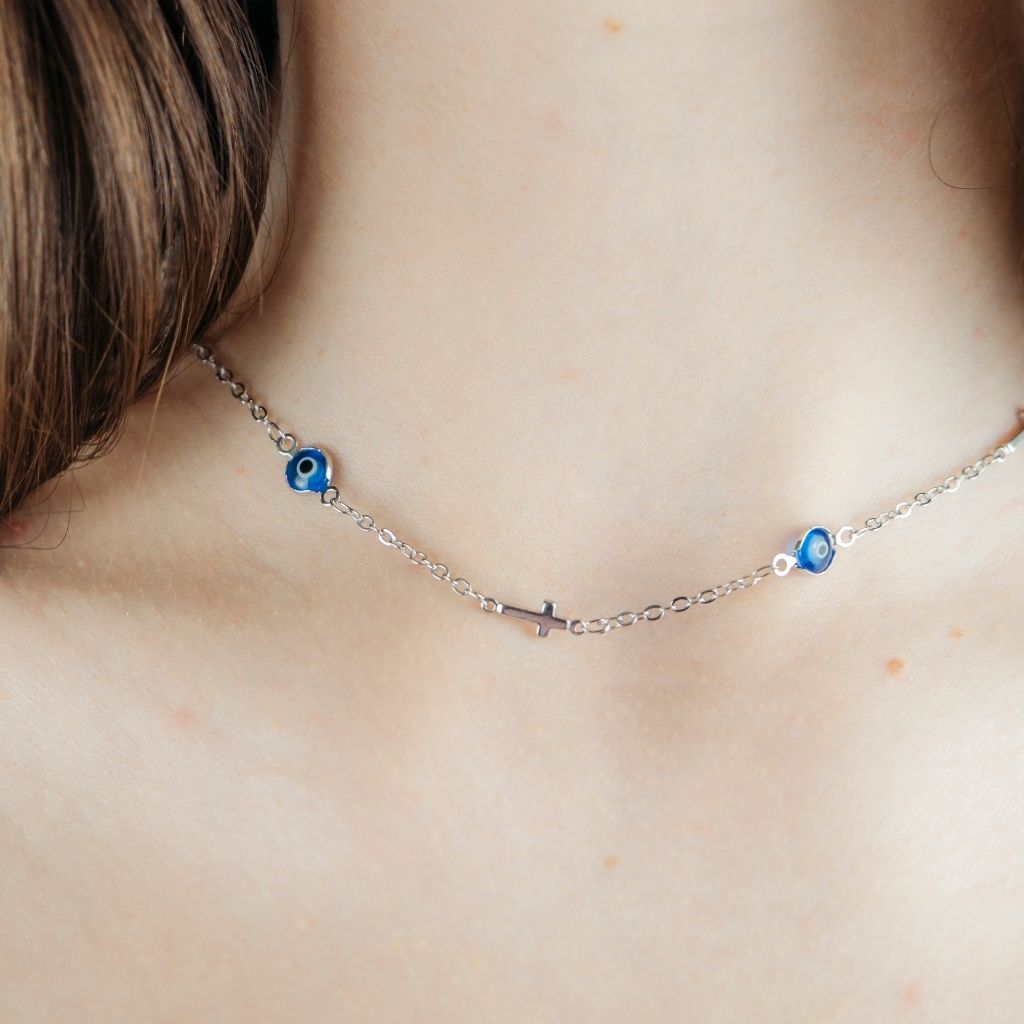 Blue Evil Eye Sideways Cross Choker featuring a dainty metal alloy chain with evil eye charms and a sideways cross design in gold and silver.