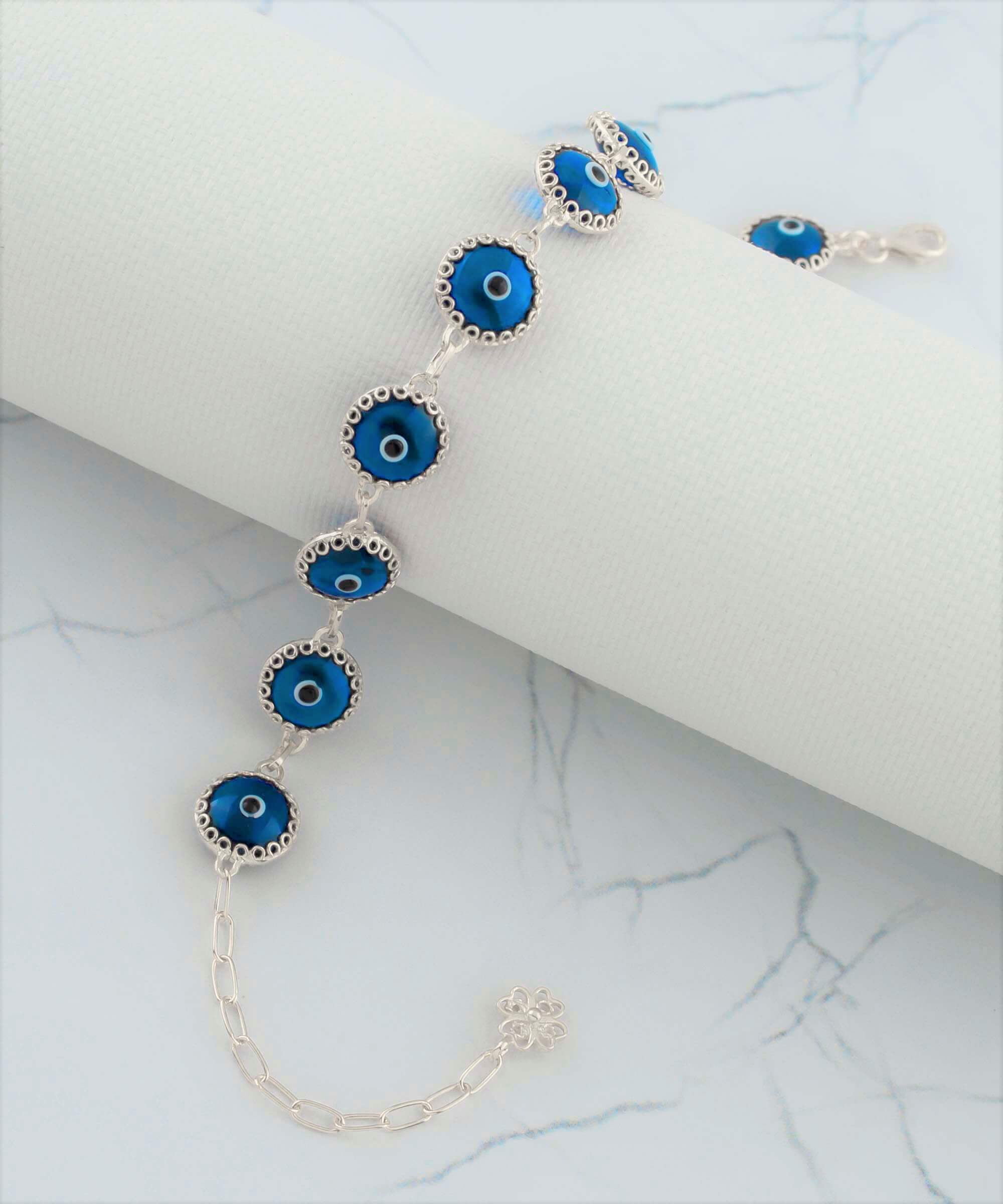 Blue Evil Eye Sterling Silver Adjustable Link Bracelet featuring a strong rolo chain and ten blue evil eye beads wrapped in silver prongs.