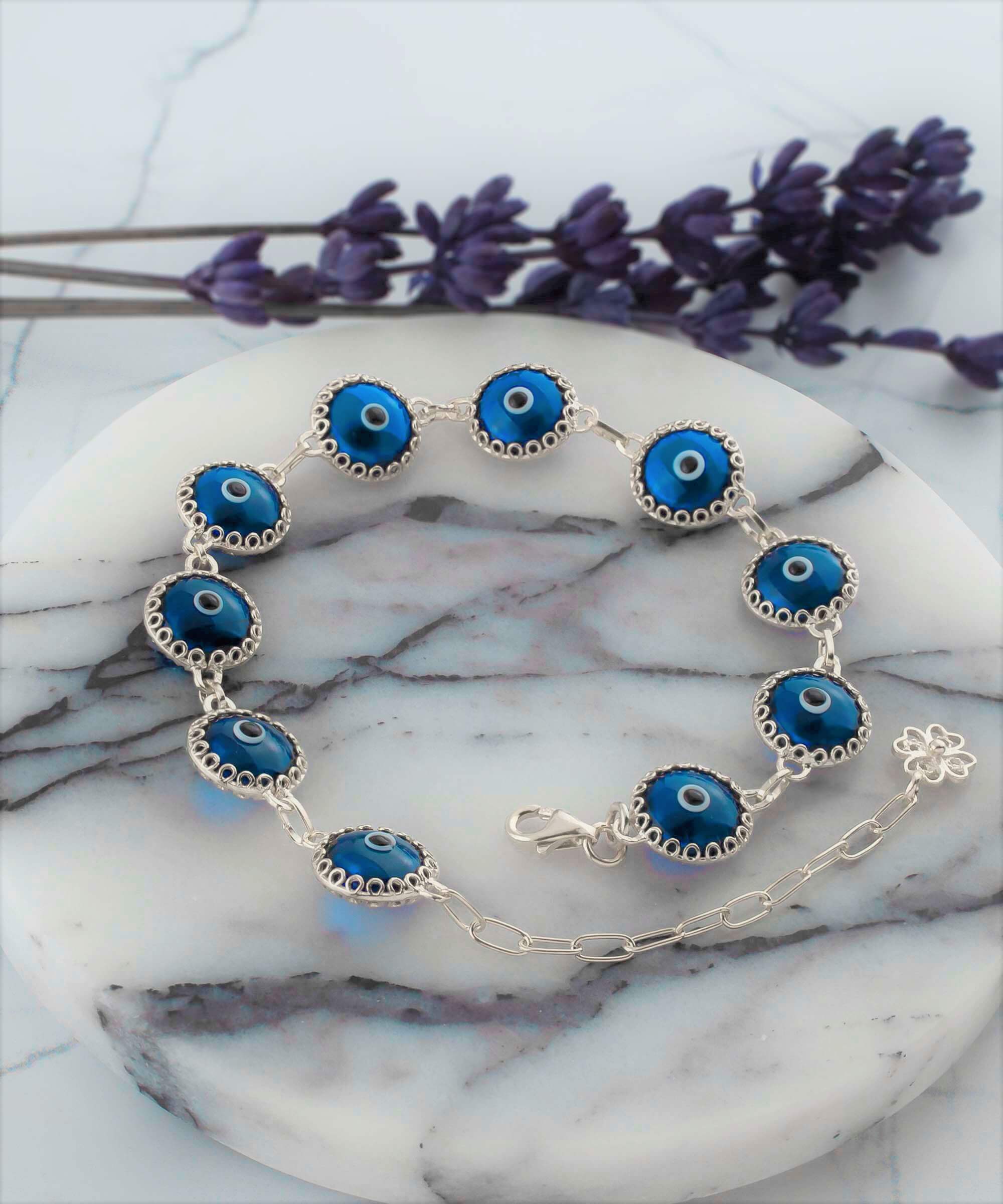 Blue Evil Eye Sterling Silver Adjustable Link Bracelet featuring a strong rolo chain and ten blue evil eye beads wrapped in silver prongs.