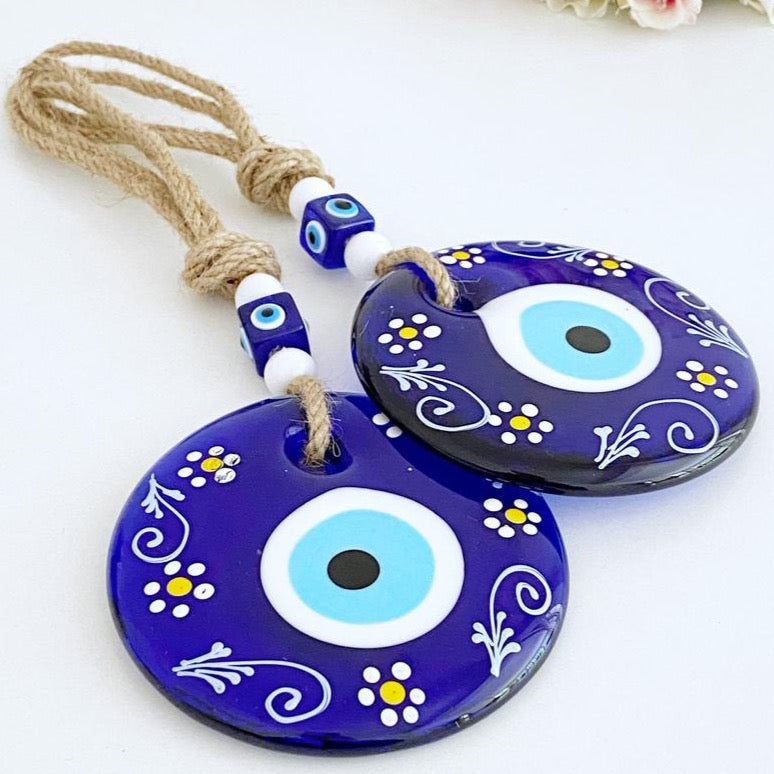 A beautifully crafted Blue Evil Eye Wall Hanging featuring macrame, painted evil eye beads, and white beads, perfect for home decor.