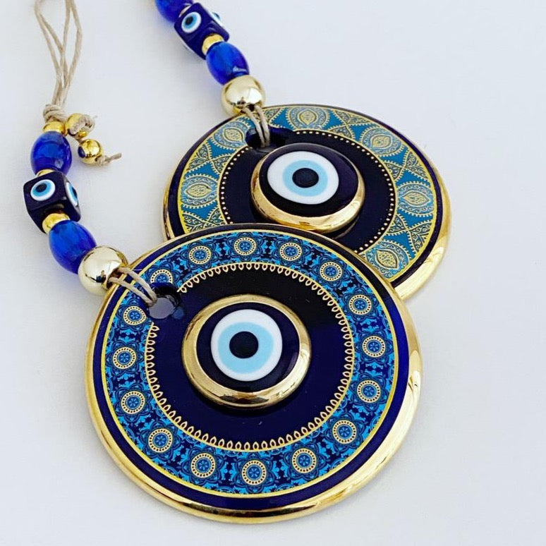 A beautiful blue evil eye wall hanging featuring intricate patterns, symbolizing protection and good luck, measuring 29cm in length.