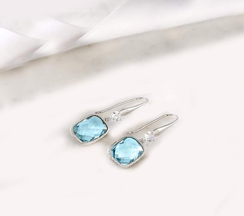 Elegant Blue Topaz Diamond Cut Drop Earrings in 18K White Gold Plated, showcasing their stunning design and craftsmanship.