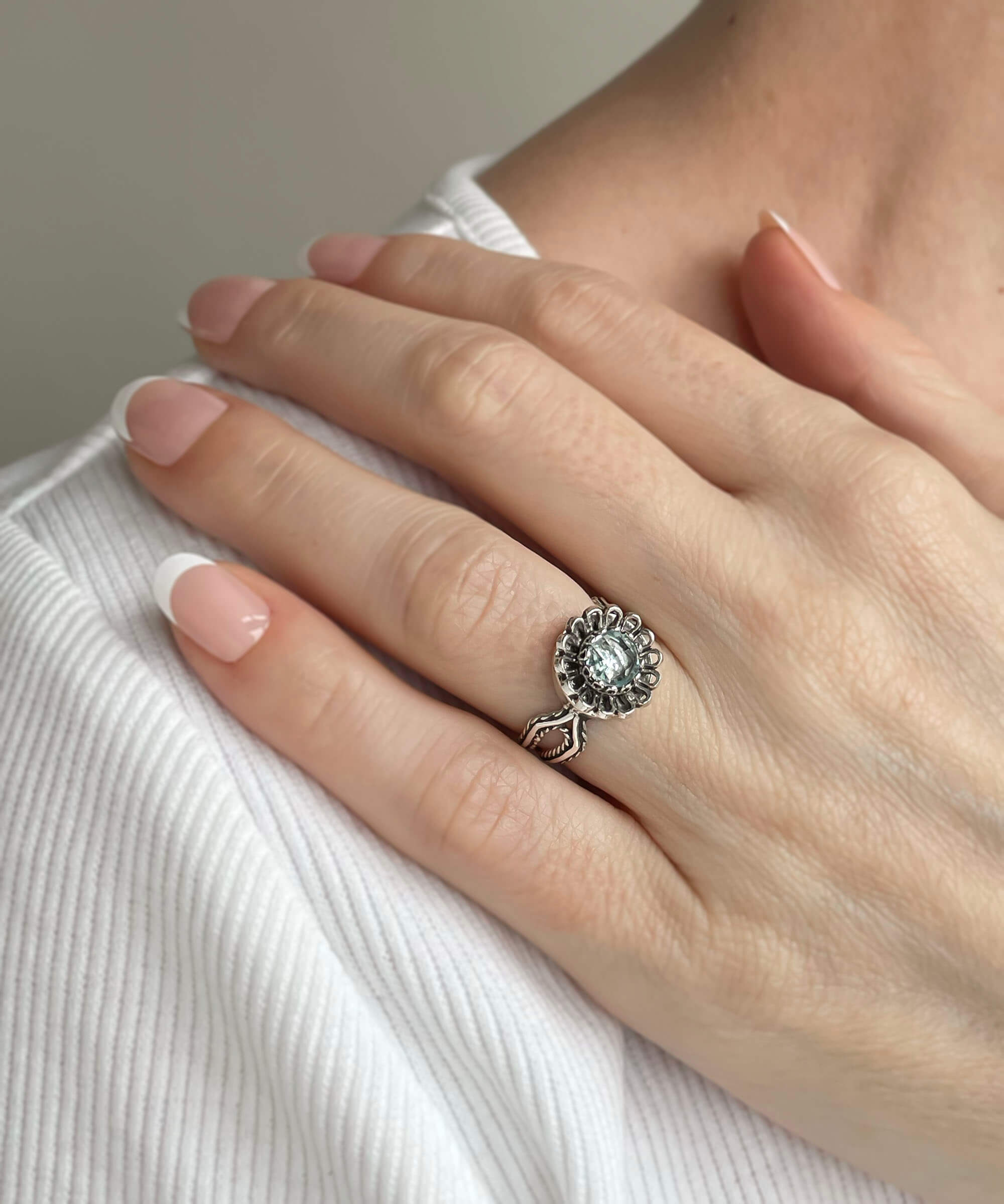 A beautiful Blue Topaz Gemstone Sterling Silver Cocktail Ring featuring a delicate lace flower design and a sparkling sky blue topaz.