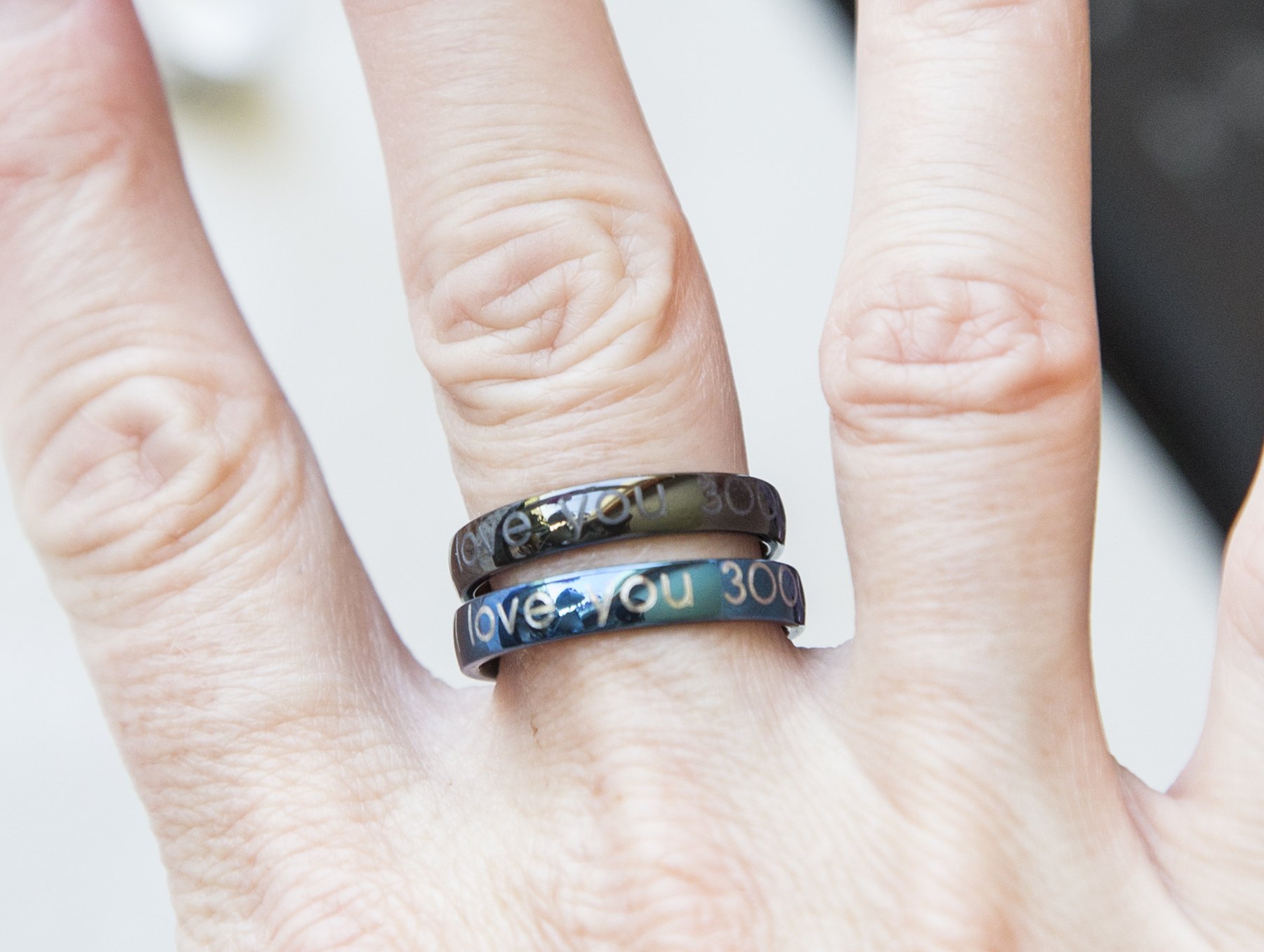 A blue stainless steel ring with a shiny finish, featuring an engraving option for personalization, ideal for gifting.