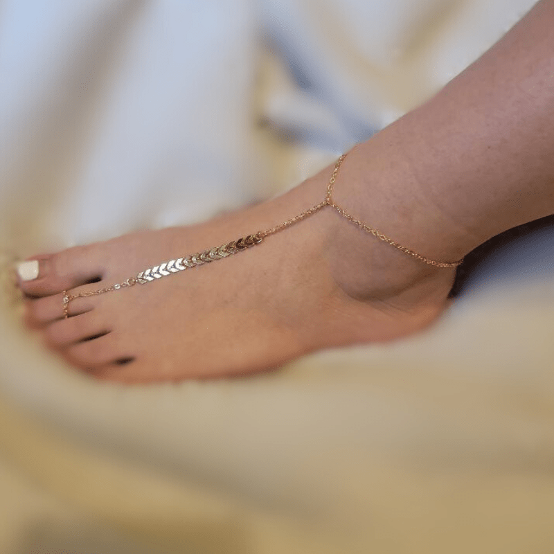 A stylish Bohemian Gold Anklet with a silver toe ring, perfect for barefoot sandals, showcasing intricate design and elegance.
