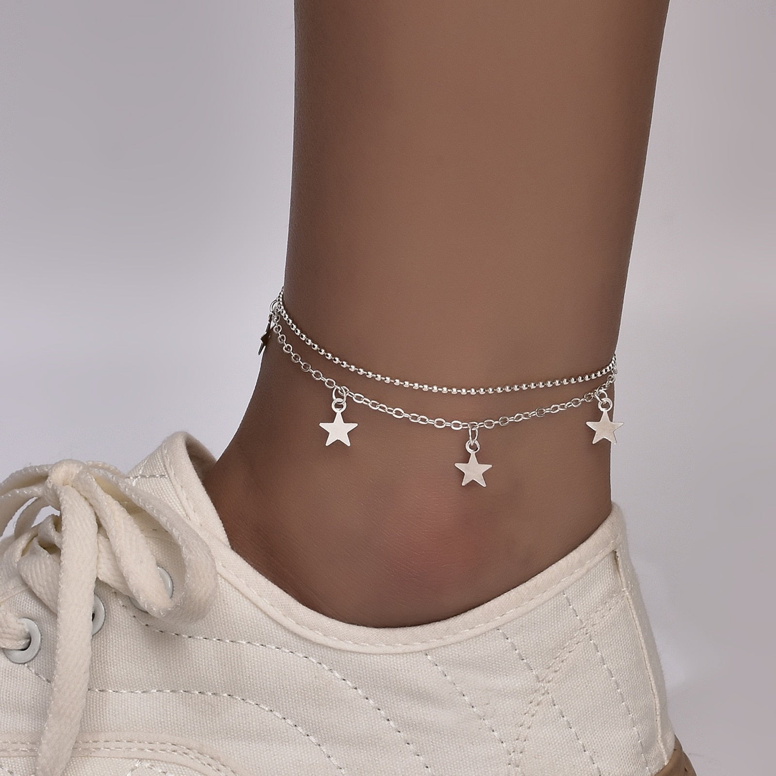 A stylish Boho Star Charm Anklet for women, featuring a star charm design in silver and gold finishes, adjustable length, and elegant packaging.