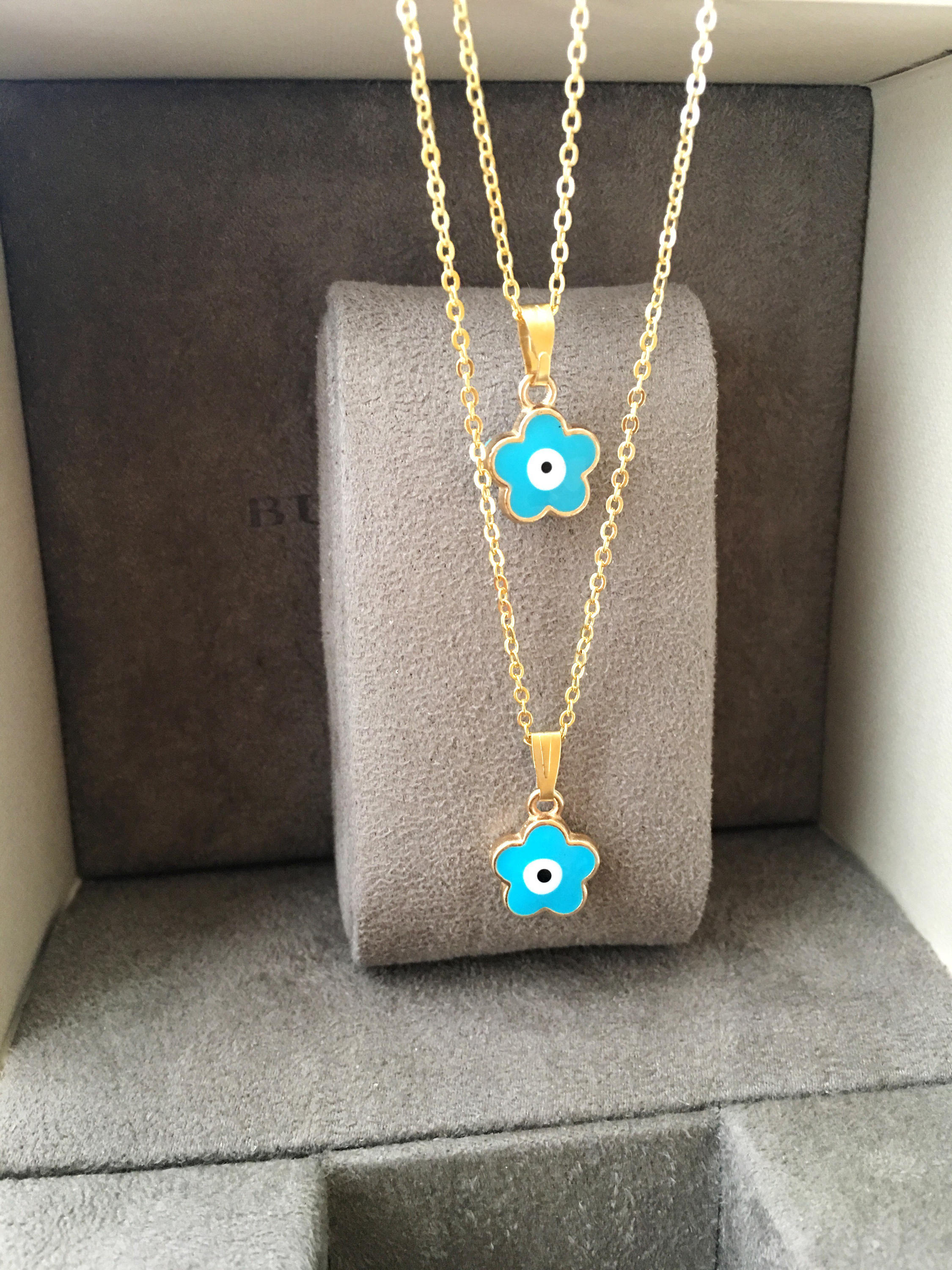 Handmade Brass Evil Eye Necklace featuring a Clover Charm on a gold chain, showcasing various color options.