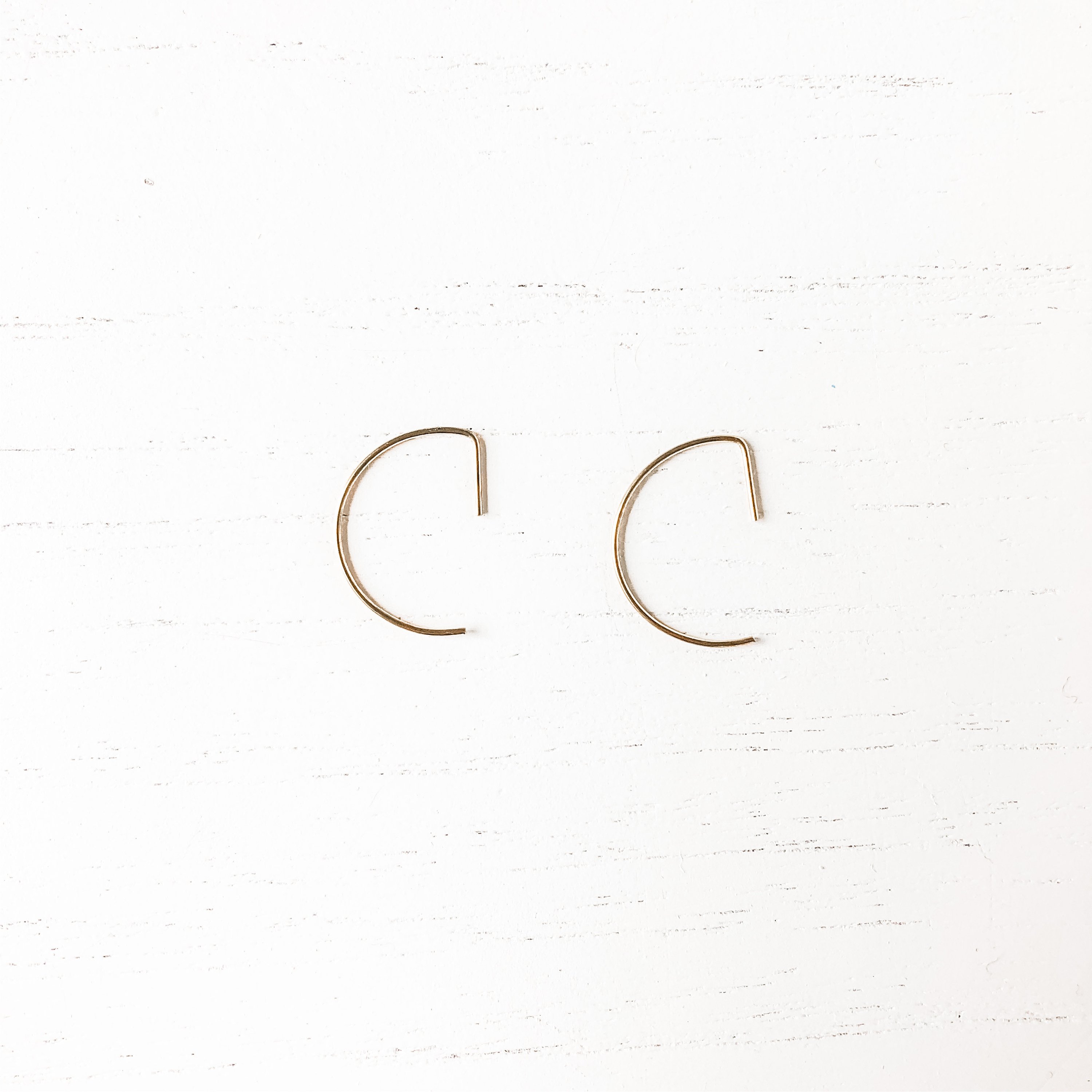 A pair of elegant brass hoop threader earrings, showcasing their lightweight design and nickel-free material.