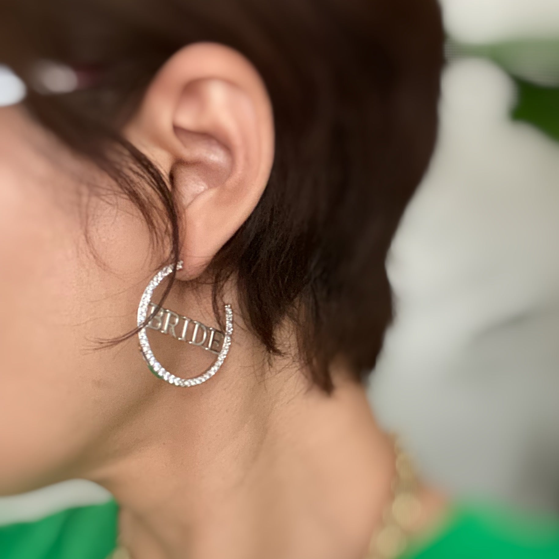 Elegant silver hoop earrings with 'BRIDE' engraving and sparkling accents, perfect for brides.