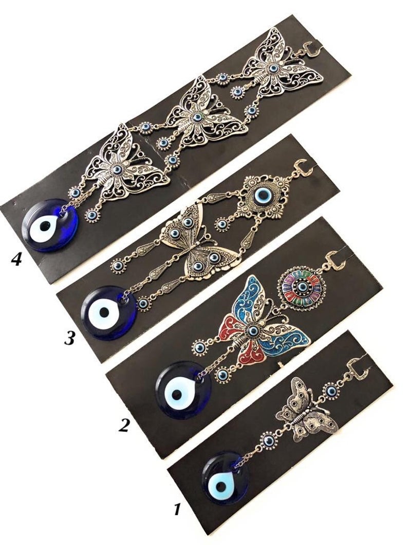 Handmade butterfly wall hanging featuring blue evil eye beads, showcasing intricate designs and vibrant colors for home decor.