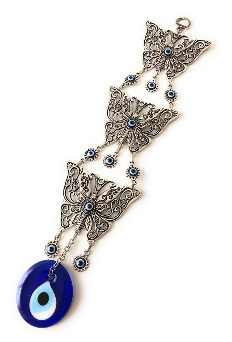 Handmade butterfly wall hanging featuring blue evil eye beads, showcasing intricate designs and vibrant colors for home decor.