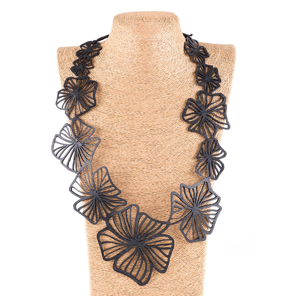 Canna Handmade Long Floral Necklace featuring unique floral patterns made from reclaimed inner tubes, displayed elegantly in a luxury gift box.