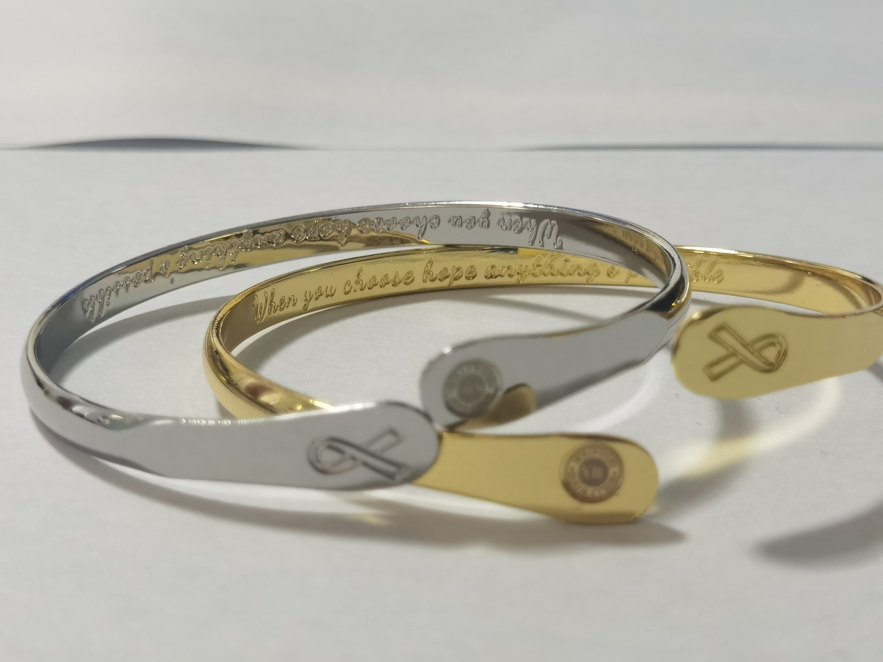 Cancer Awareness Bracelet engraved with 'When you choose hope anything’s possible' and a cancer awareness sign, featuring white gold plating.