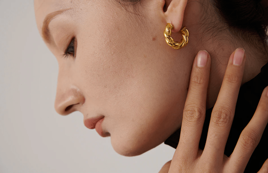 Candy Twisted Nugget Creoles earrings featuring a unique twisted design in stainless steel with 18Kt yellow gold coating.