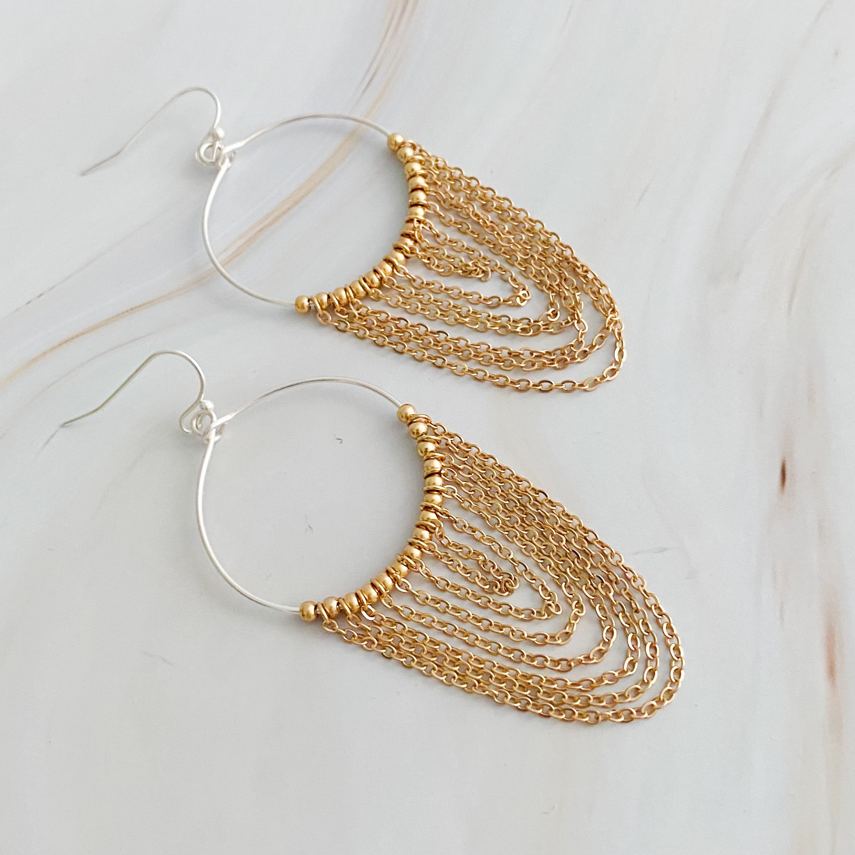 Elegant Chain Drapes Two Tone Earrings featuring gold and silver draping chains and slim hoops.