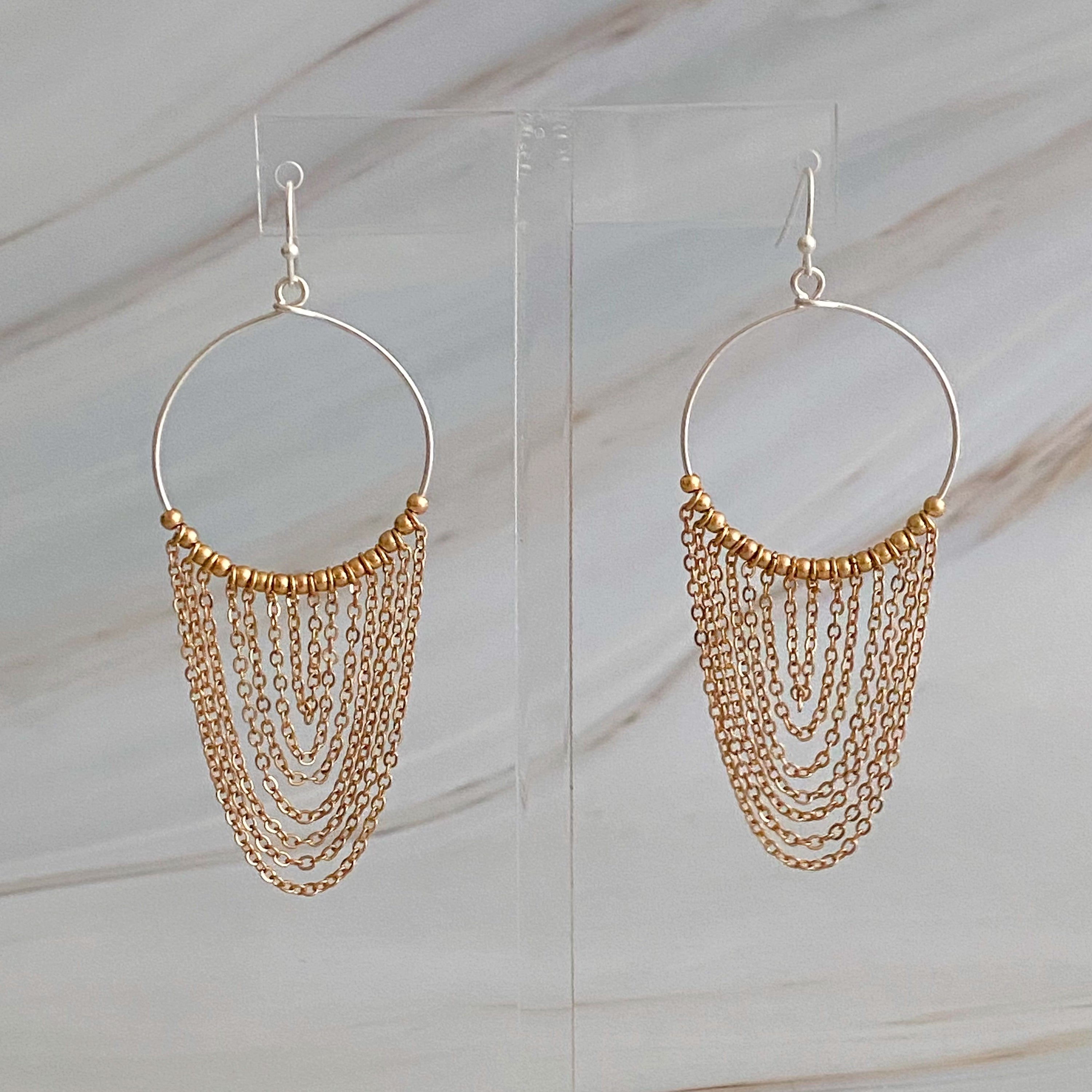 Elegant Chain Drapes Two Tone Earrings featuring gold and silver draping chains and slim hoops.