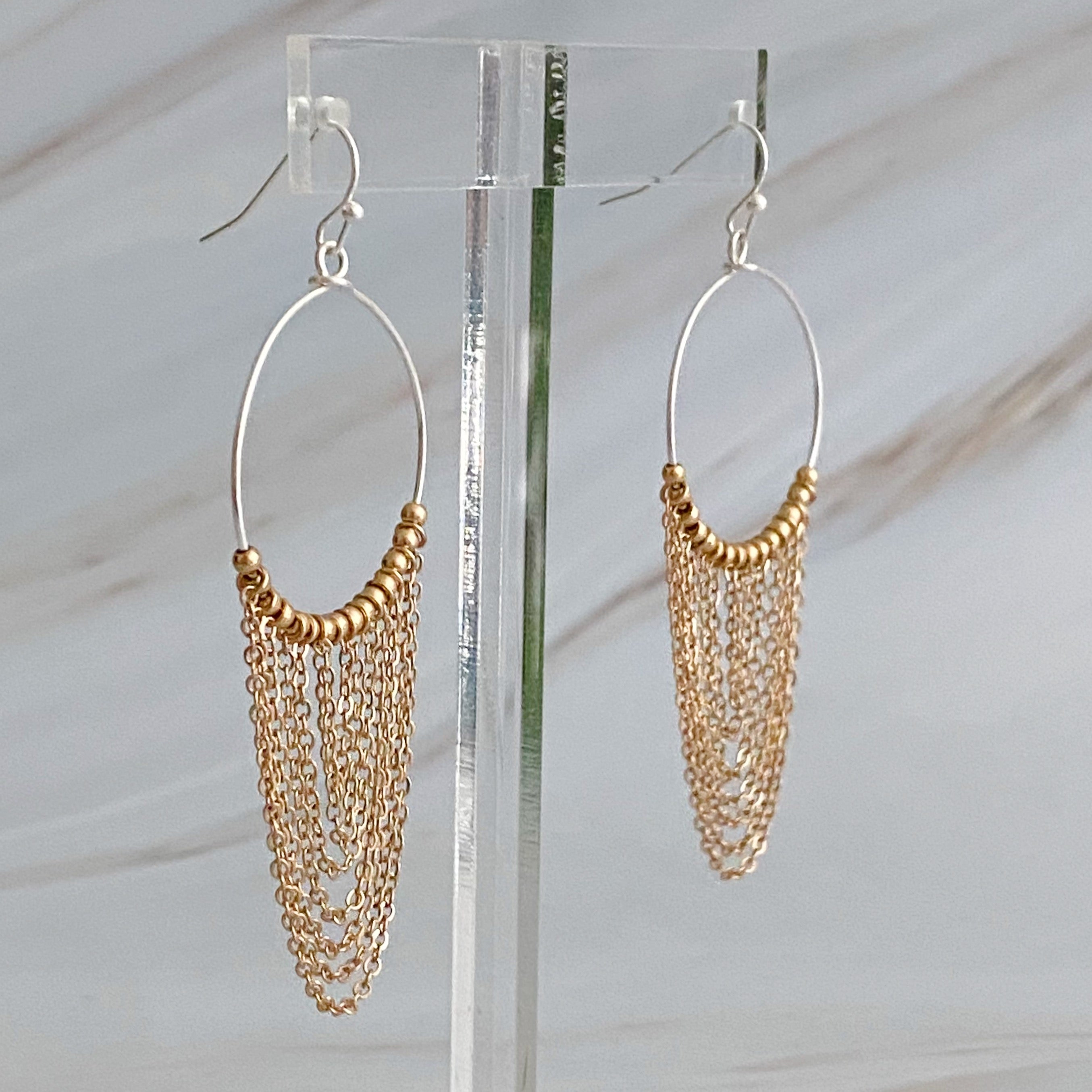 Elegant Chain Drapes Two Tone Earrings featuring gold and silver draping chains and slim hoops.