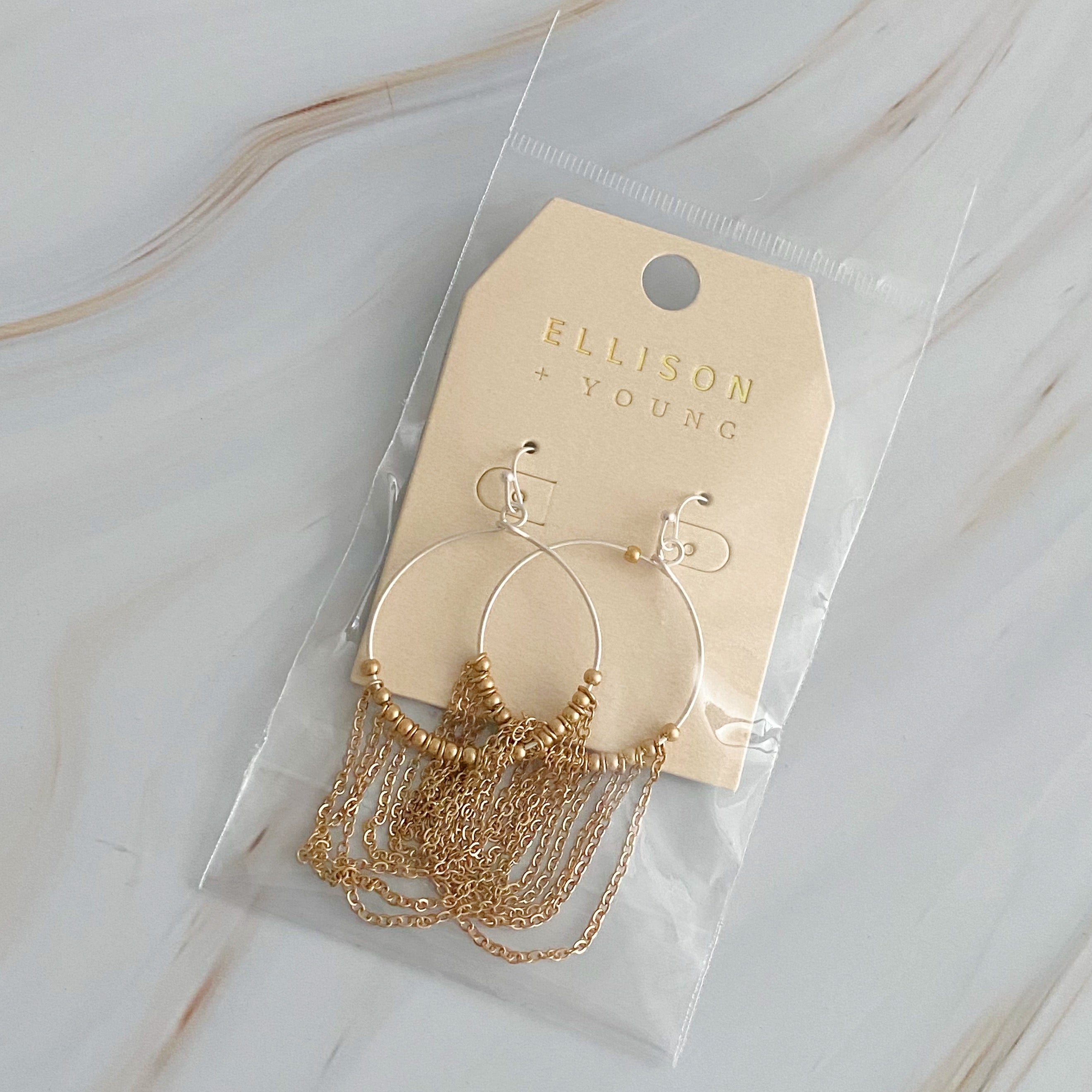 Elegant Chain Drapes Two Tone Earrings featuring gold and silver draping chains and slim hoops.