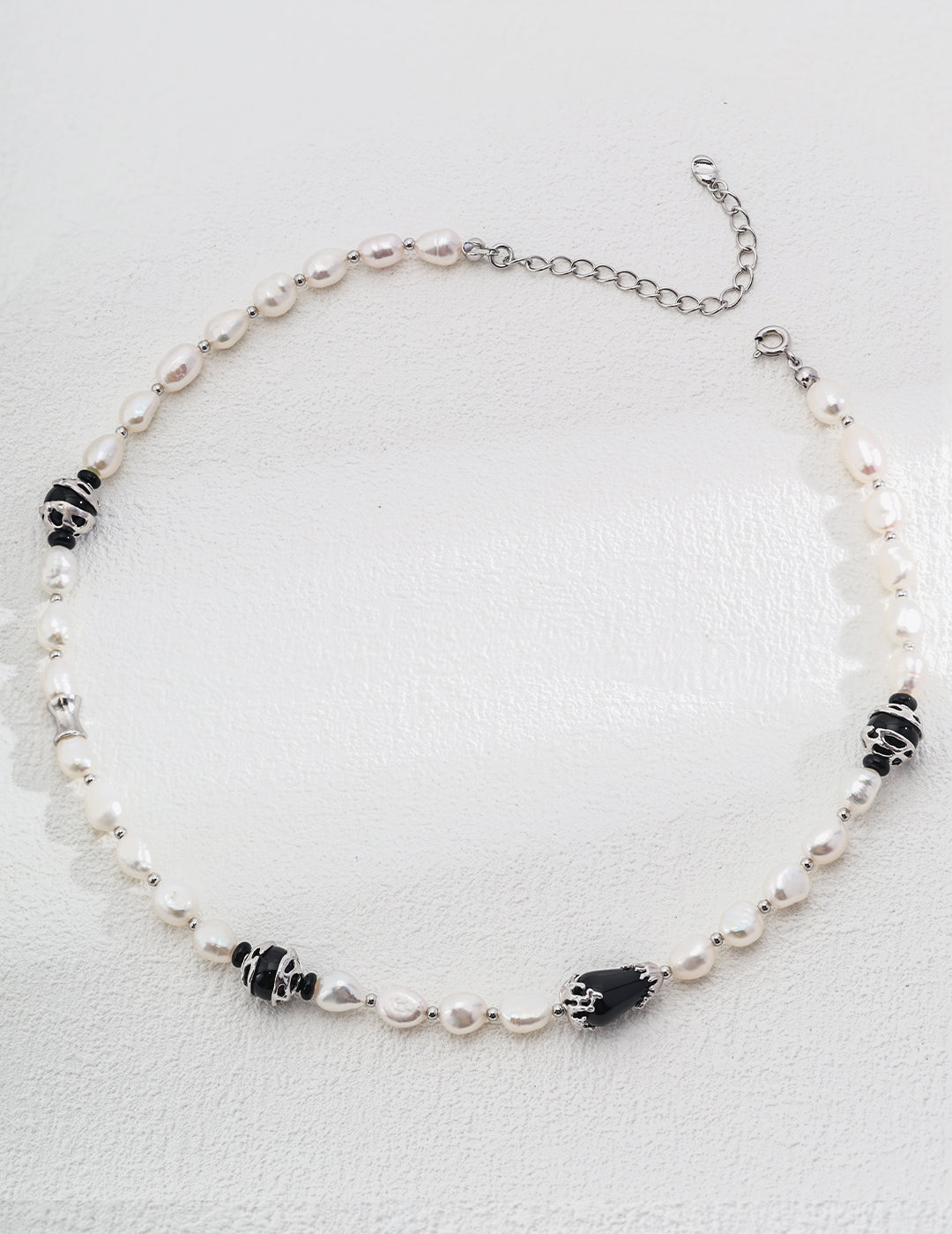 Chic Pure Silver Pearl Necklace featuring elegant white pearls and striking black onyx, showcasing a sophisticated design.