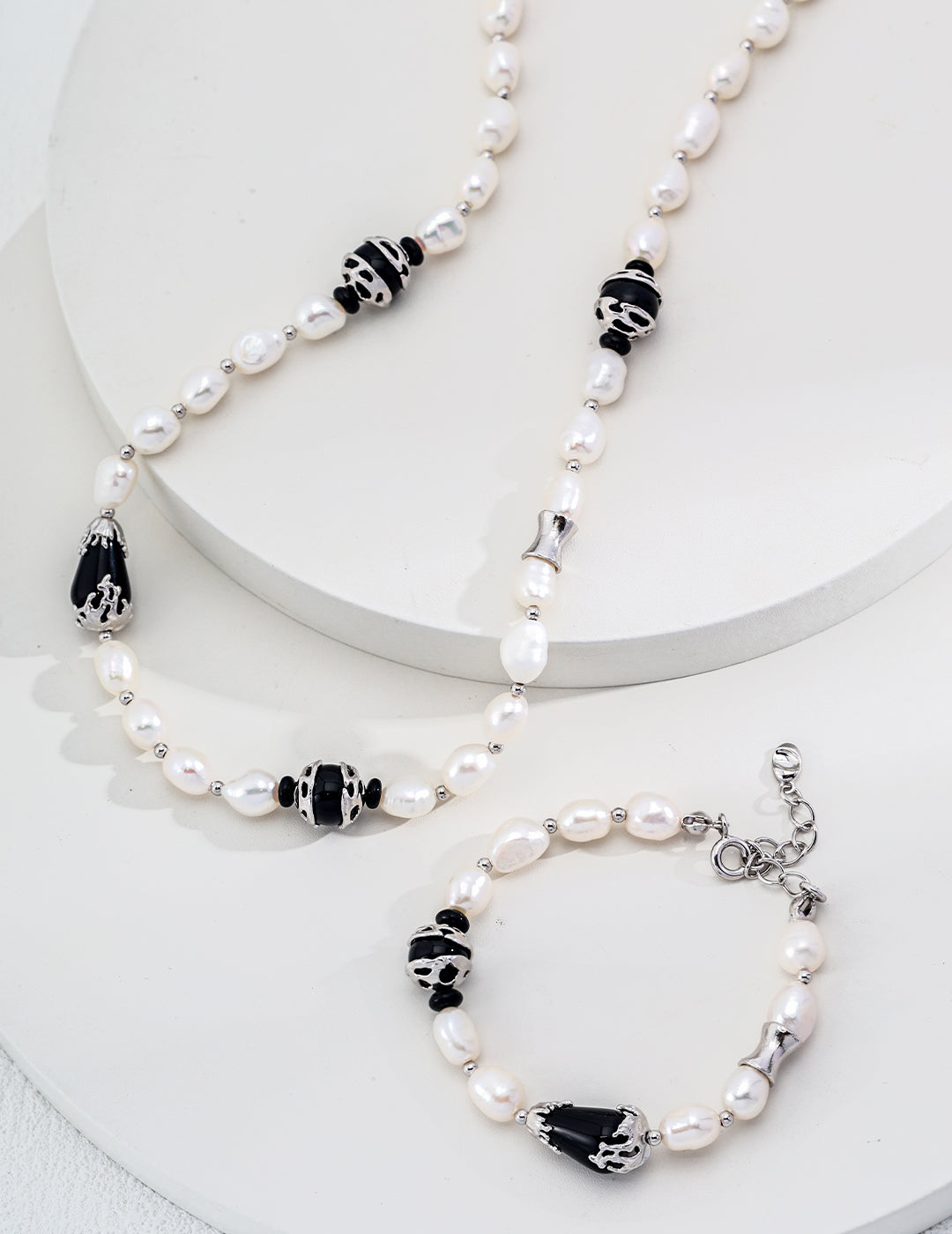 Chic Pure Silver Pearl Necklace featuring elegant white pearls and striking black onyx, showcasing a sophisticated design.